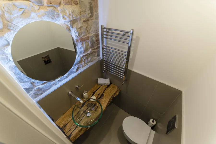 Ristrutturazione Casa Castelbuono - Lavello in vetro e specchio retroilluminato su parete in pietra
